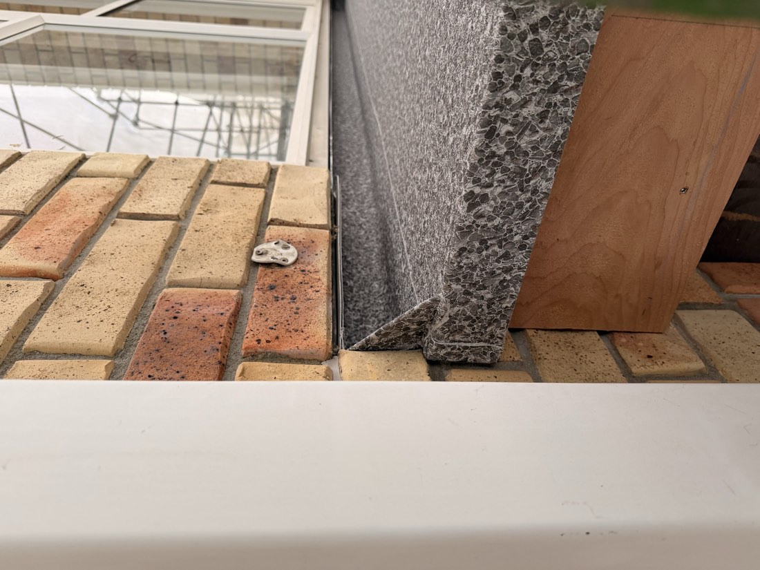 Dec-K-Ing vinyl deck surface turned up and terminated against a brick wall