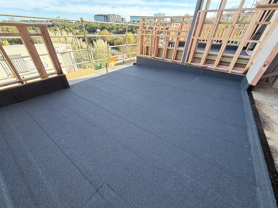 Membrane-waterproofed deck on an Auckland new build, upstands dressed up against the framing