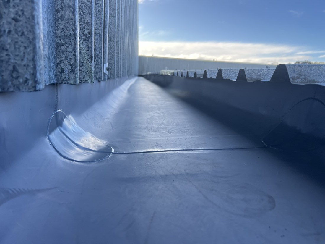 Membrane repair detailed into the wall junction and outlet on an Auckland roof